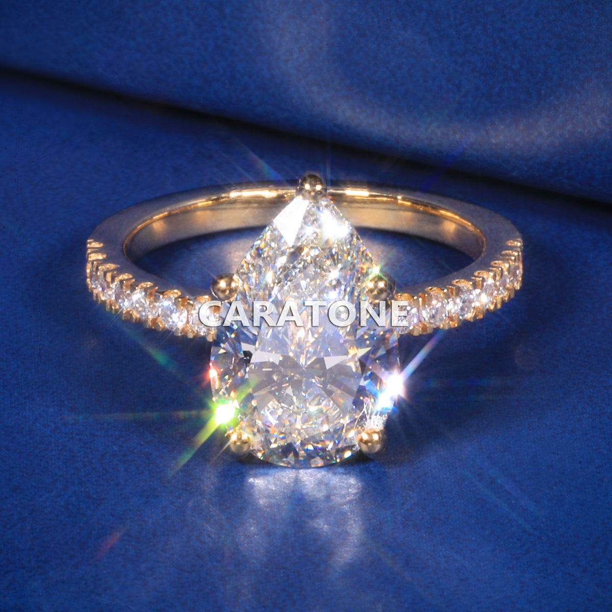Exclusive Premium Pear Cut Solitaire Ring With Brilliant White Center Stone, Sparkling Pave Set Side Stones, Elegant Yellow Gold Tone Band And Unique Luxury Designer Engagement Jewelry For Women